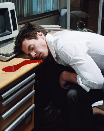 Office worker dead at his deskの写真素材