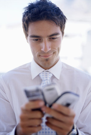 Man choosing between mobile phonesの写真素材