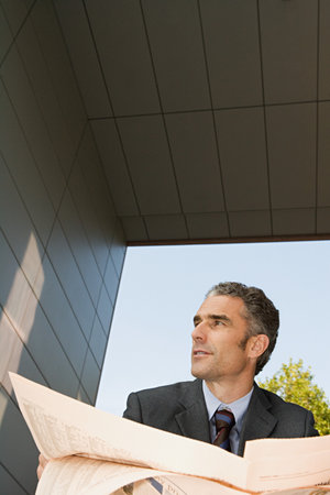 Businessman with financial newspaperの写真素材