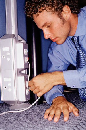 Man putting computer cable into a socketの写真素材