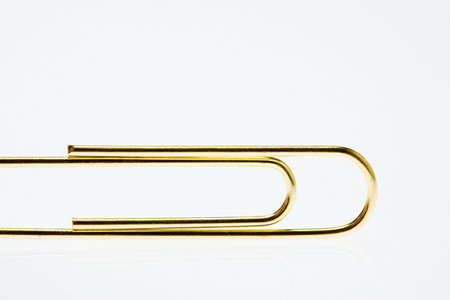 Golden paperclip background.の写真素材