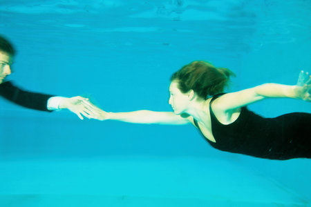 A couple dancing in a swimming poolの写真素材
