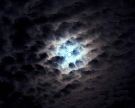 Moonlight through cloudy skyの写真素材