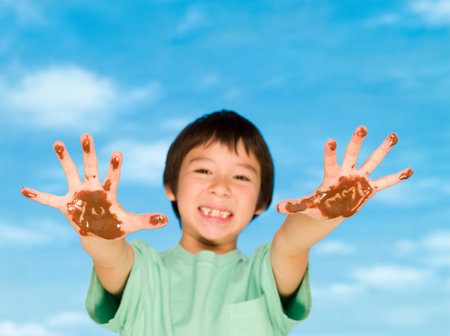 A boy with chocolate covered handsの写真素材