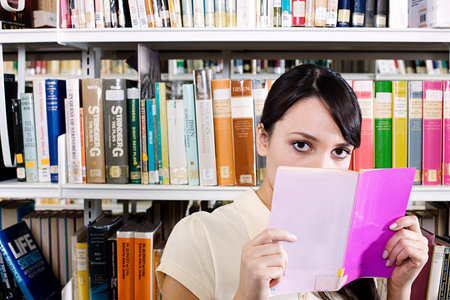 Young woman in library with bookのeditorial素材