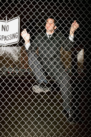 Businessman climbing a fenceの写真素材