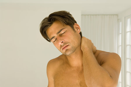 Man rubbing his neckの写真素材