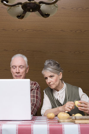 Man with laptop and wife with potatoesの写真素材