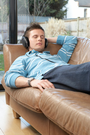 Man listening to music on sofa