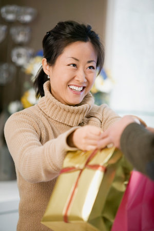 Woman handing over bagsの写真素材