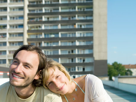 Young couple by apartment buildingの写真素材