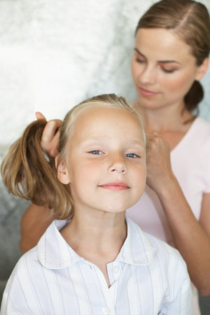 Mother styling her daughters hairの写真素材