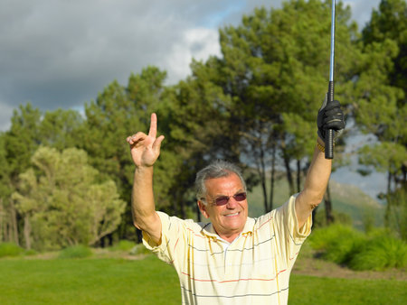 Golf with arms raisedの写真素材