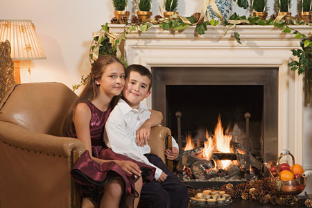 Children by fireplace at christmasの写真素材