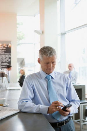Man using handheld computer at bar counterの写真素材