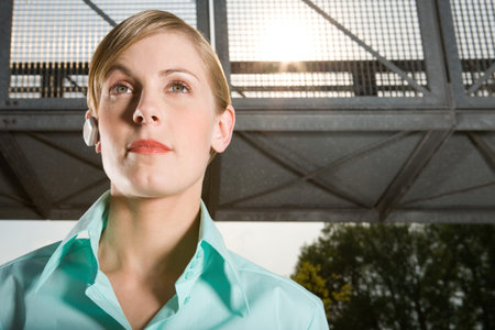 Woman wearing headset standing outdoorsの写真素材