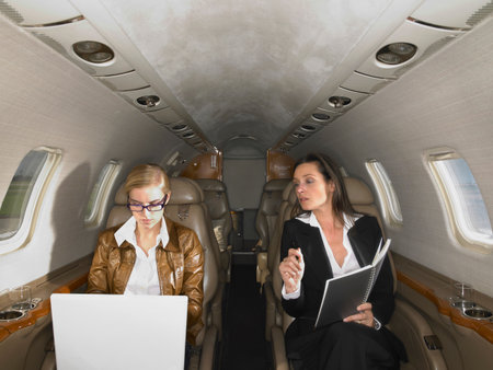 Two women in private jet having a discussion.の写真素材