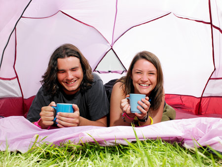 Couple with mugs in pink tentの写真素材