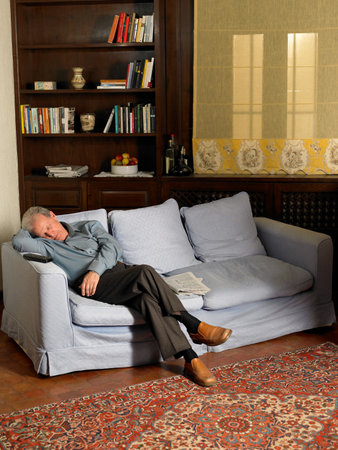 Senior Adult man asleep on sofaの写真素材