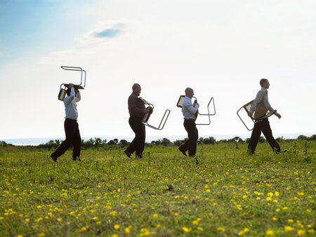 Businessmen walking through fieldの写真素材
