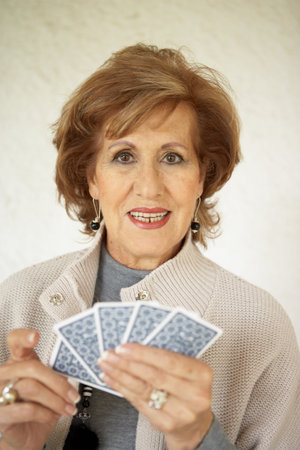 Senior woman holding playing cardsの写真素材