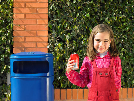 Young girl with can next to binの写真素材