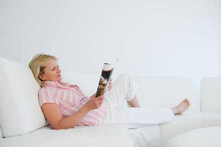 Woman relaxing with magazineの写真素材