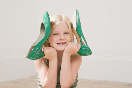 Girl holding a large pair of high heeled shoesの写真素材