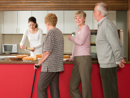Seniors queuing for cakeの写真素材