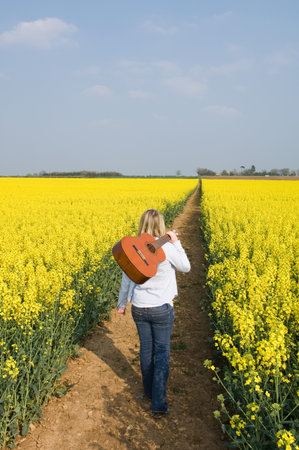 Woman in field with guitarの写真素材