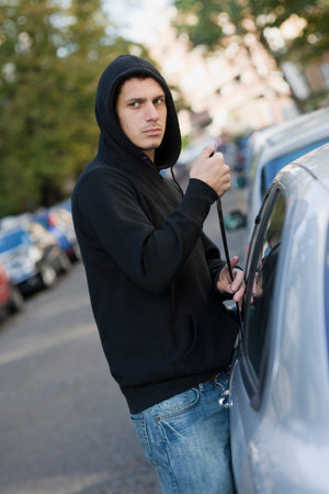 A thief breaking into a carの写真素材