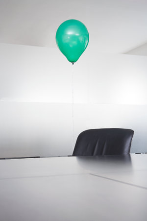 Green balloon in an officeの写真素材