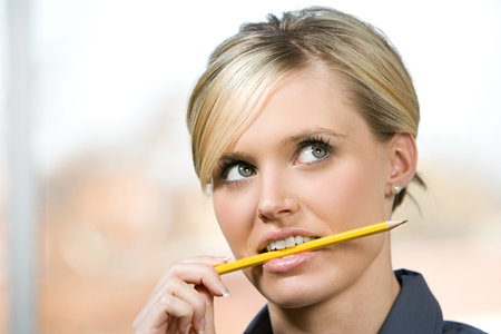 An office worker biting on a pencilの写真素材