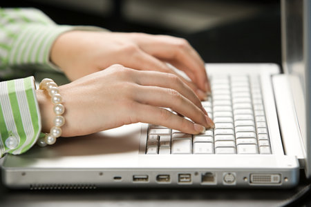 An office worker typing on a laptopの写真素材