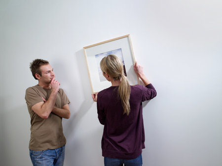 A couple putting art on a wall