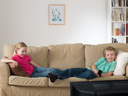A sister and brother watching tvの写真素材