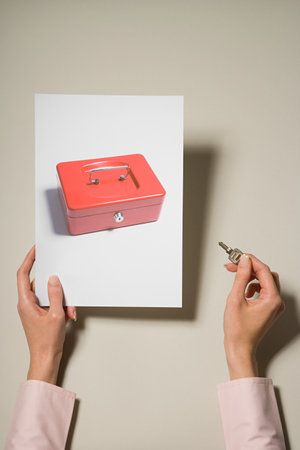 A woman holding a photograph of a cash box and a keyの写真素材