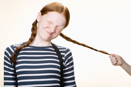 A girl having her pigtail pulled