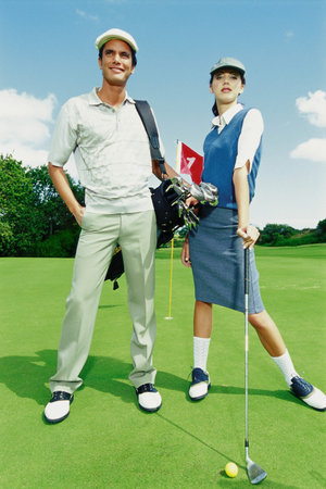 Man and woman playing golfの写真素材
