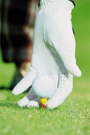 Gloved hand with golf ballの写真素材