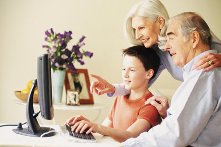 Grandparents and grandson using computerの写真素材