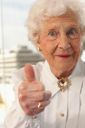 Elderly woman giving the thumbs upの写真素材