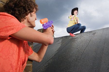 Couple playing with water pistols
