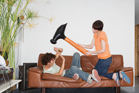 Couple playing with inflatable hammerの写真素材
