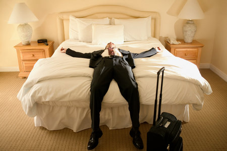 A businessman lying on a bedの写真素材