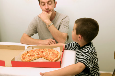 Father and son looking at a pizzaの写真素材