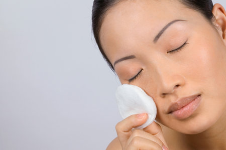 Woman applying make-up with cotton padの写真素材