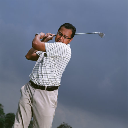 Man swinging golf clubの写真素材