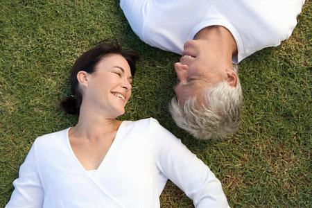 Mature couple lying on the grassの写真素材