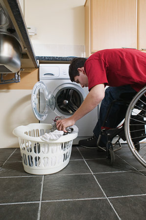 Disabled man doing laundryの写真素材